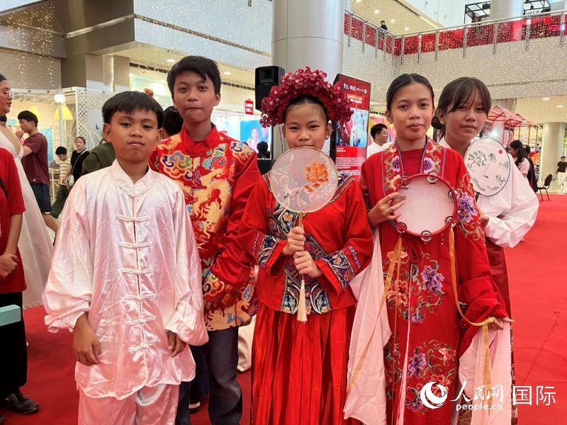 中国传统服饰体验区成为人气焦点，菲律宾民众纷纷试穿拍照。人民网记者 樊帆摄